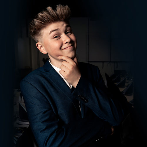 Frisk konfirmand poserer med hånd ved hagen